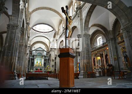 Jesus am Kreuz mit einer gewölbten Steindecke im Hintergrund im Inneren der Basílica Colegiata de Nuestra Señora de Guanajuato in Mexiko. Stockfoto