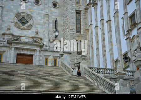 Studentin, die auf der Steinbruchtreppe der Universität von Guanajuato im historischen Zentrum von Guanajuato in Mexiko sitzt. Stockfoto