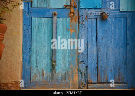 Antike hellblaue Holztür an einer verwitterten Steinwand in Guanajuato, Mexiko. Stockfoto