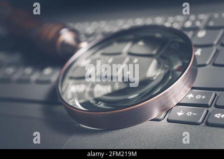 Vintage-Lupe auf EINER grauen Computertastatur - Suchmaschine Optimierungskonzept Stockfoto