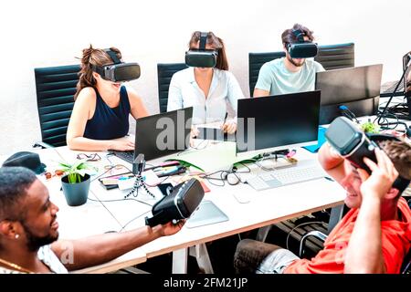 Junge Leute, Angestellte, die Spaß mit der virtuellen Realität haben Schutzbrille im Startup-Office - Human Resource Business-Konzept bei Alternative Studio Stockfoto