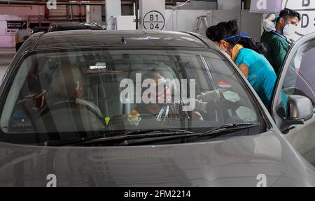 Mumbai, Indien. Mai 2021. Eine medizinische Mitarbeiterin mit Gesichtsmaske verabreicht einer Frau in ihrem Auto auf dem öffentlichen Parkplatz von Kohinoor in Mumbai eine COVID19-Impfdosis. Diese Einrichtung ist für Senioren und unterschiedlich behinderte Menschen geöffnet. Kredit: SOPA Images Limited/Alamy Live Nachrichten Stockfoto