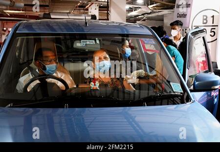 Mumbai, Indien. Mai 2021. Eine medizinische Mitarbeiterin mit Gesichtsmaske verabreicht einer Frau in ihrem Auto auf dem öffentlichen Parkplatz von Kohinoor in Mumbai eine COVID19-Impfdosis. Diese Einrichtung ist für Senioren und unterschiedlich behinderte Menschen geöffnet. Kredit: SOPA Images Limited/Alamy Live Nachrichten Stockfoto