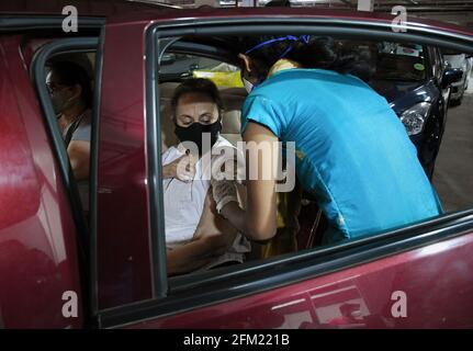 Mumbai, Indien. Mai 2021. Eine medizinische Mitarbeiterin mit Gesichtsmaske verabreicht einer Frau in ihrem Auto auf dem öffentlichen Parkplatz von Kohinoor in Mumbai eine COVID19-Impfdosis. Diese Einrichtung ist für Senioren und unterschiedlich behinderte Menschen geöffnet. Kredit: SOPA Images Limited/Alamy Live Nachrichten Stockfoto