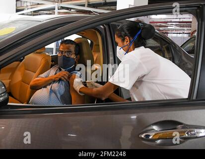 Mumbai, Indien. Mai 2021. Ein Mitarbeiter im Gesundheitswesen, der eine Gesichtsmaske trägt, verabreicht einem Mann in seinem Auto auf dem öffentlichen Parkplatz von Kohinoor in Mumbai eine COVID19-Impfdosis. Diese Einrichtung ist für Senioren und unterschiedlich behinderte Menschen geöffnet. Kredit: SOPA Images Limited/Alamy Live Nachrichten Stockfoto