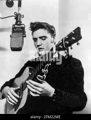 Elvis Presley im RCA Victor Studio A (aka Studio 1) in New York City am 1. Dezember 1955 mit einer geliehenen Gitarre und einem vintage RCA 44A Mikrofon. (USA) Stockfoto