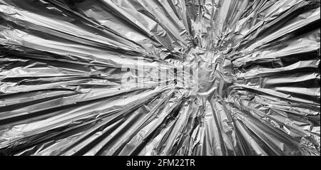 Metallhintergrund als metallische und silberne oder verchromte Legierung in Form eines Stahlbanners in einem Sternstoß-Muster, das von einem Mittelpunkt ausstrahlt. Stockfoto