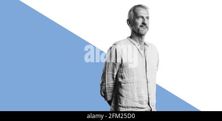 Leitender Mann isoliert auf zweifarbigem Hintergrund. Mann, der mit den Händen hinter ihm steht und wegschaut. Stockfoto