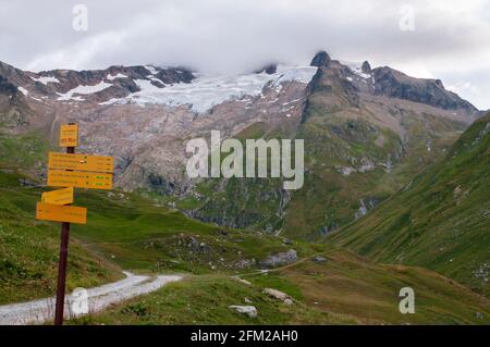 Wanderschilder auf dem Wanderweg GR Tour du Mont-Blanc in der Nähe der Hütte des Mottets mit Blick auf den Gletscher des Glaciers, Chapieux Valley, Savoie (73), A Stockfoto