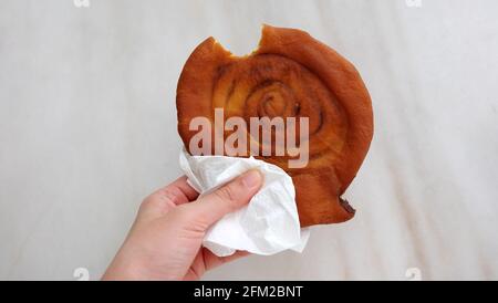 Eine Hand, die ein Stück Ham Chim Peng hält. Schinken-Chim peng, was salziger gebratener Pfannkuchen bedeutet, ist ein tiefgebratener Hohldonut chinesischer Herkunft. Stockfoto