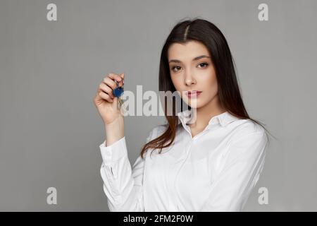 Schöne junge Brünette Frau hält Hausschlüssel Stockfoto