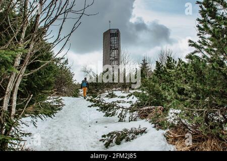 Rucksacktouristen zu Fuß zum Aussichtsturm Velka Destna, Orlicke, Adler, Gebirge, Tschechien. Genießen Sie die Freiheit des Winterwanderns, aktiven Lebensstils und der Landschaft Stockfoto