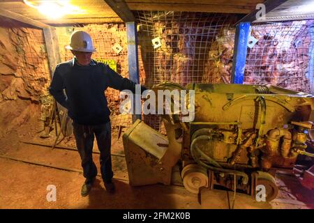 Tennant Creek, Australien - 2019. August: Ehemaliger Bergmann zeigt während der Führung einen Steinbrecherwagen auf der Schiene im Battery Hill Mining Center Museum. Stockfoto