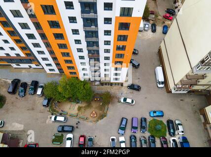 Luftaufnahme von geparkten Autos auf dem Parkplatz zwischen hohen Wohngebäuden. Stockfoto