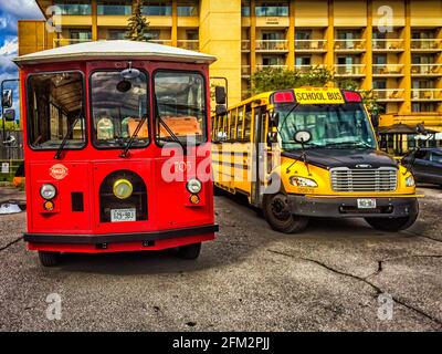 Ontario, Kanada, 2019. September, Nahaufnahme eines roten Kingston Trolley Busses für eine Führung durch die Stadt und einen gelben Schulbus Stockfoto
