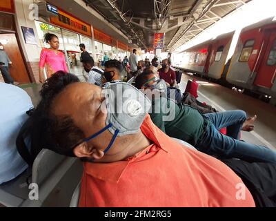 Passagiere, die dem Covid-19-Protokoll folgen, warten auf dem Bahnsteig an der Kamakhya Junction in Guwahati, der Hauptstadt Assam, Indien. Stockfoto