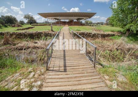 Zugang über eine Fußgängerbrücke zur archäologischen Stätte Cancho Roano. Zalamea de la Serena, Badajoz, Extremadura, Spanien Stockfoto