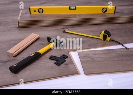 Ausrüstung oder Werkzeuge zur Installation von Laminatboden, Hammer, Hammer, Distanzstücken, Wasserwaage und Messgerät. Selektiver Fokus. Stockfoto