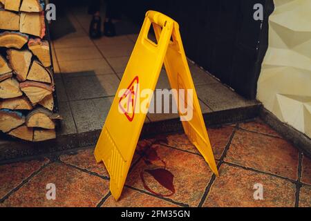 Gelbes Schild, die für nassen Boden alarmiert Stockfoto