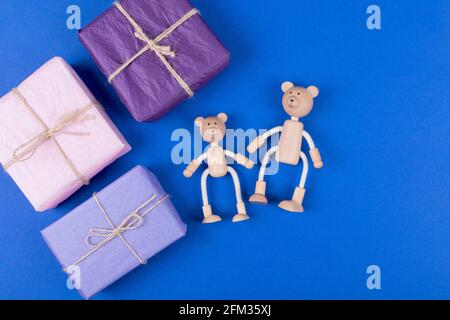 Alles gute zum Vatertag Hintergrund. Grußkarte mit einer Familie von Teddybären aus Holz und einer Geschenkbox auf blauem Hintergrund. Flach liegend. Speicherplatz kopieren. Stockfoto