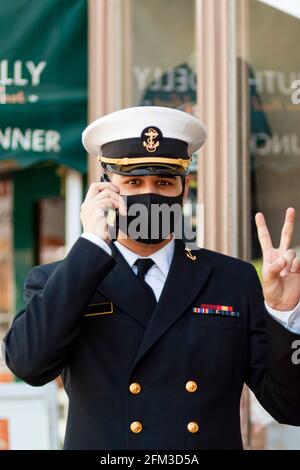 Annapolis, MD, USA 05-02-2021: Ein Kadett, der an der US Naval Academy teilnimmt, trägt wegen der COVID 19-Pandemie eine Gesichtsmaske. Der junge Auszubildende spricht darüber Stockfoto