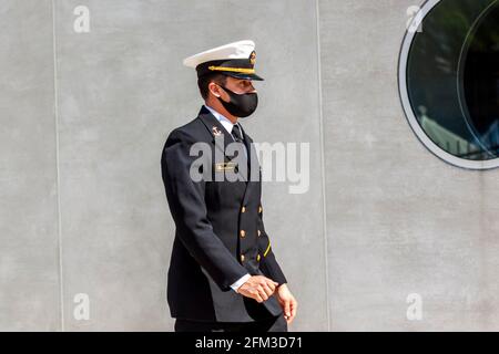 Annapolis, MD, USA 05-02-2021: Ein Kadett, der an der US Naval Academy (USNA) teilnimmt, trägt wegen der COVID 19-Pandemie eine Gesichtsmaske. Der junge Auszubildende ist Walk Stockfoto