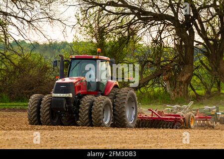 Chestertown, MD, USA 05-02-2021: Roter Sechsradkoffer IH Magnum 305 mit Kabine pflügt im Frühjahr ein leeres Agrarfeld. Der Pflug A Stockfoto