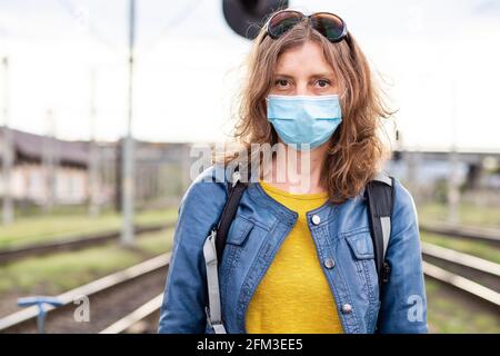 Frau mit Maske im Bahnhof Stockfoto