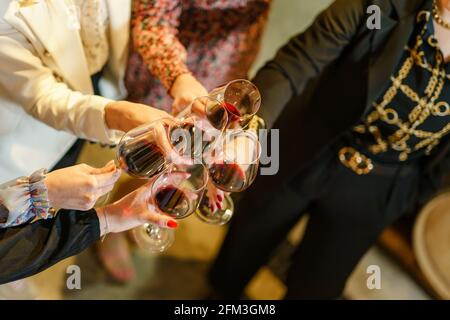 Nahaufnahme der Hände unbekannter Frauen, die eine Brille halten Von Rotwein-Toasten Stockfoto
