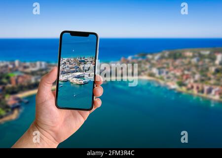 Mann, der mit dem Mobiltelefon fotografiert, mit verschwommener Landschaft im Hintergrund, Nahaufnahme der Hand. Platz für Text Stockfoto