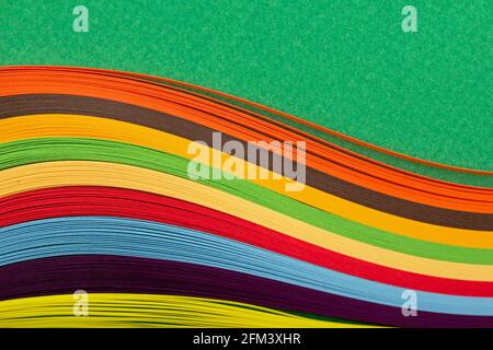 Curl Regenbogen Streifen Papier auf grünem Hintergrund. Stockfoto