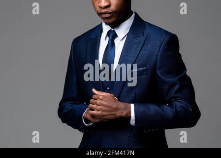 Anonymer junger afrikanischer Mann in formellem Business-Anzug im Studio Grauer isolierter Hintergrund Stockfoto