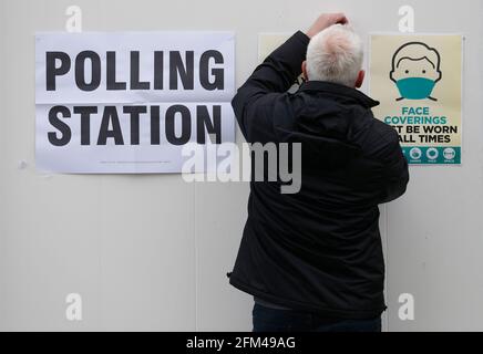 Shepshed, Leicestershire, Großbritannien. Mai 2021. Während der Kommunalwahlen hängt ein Beamter mit einem Gesicht, das Schilder auf einem Wahllokal in einer mobilen Einheit bedeckt. Millionen von Menschen in ganz Großbritannien werden am Donnerstag mit der größten Stimmenzahl seit den Parlamentswahlen 2019 abstimmen. Credit Darren Staples/Alamy Live News. Stockfoto