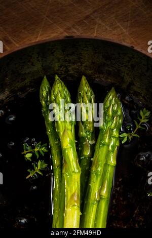 Spargelspieße in Bratpfanne auf Holzhackbrett, gutes Essen, gesundes Essen. Stockfoto