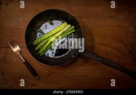 Spargelspieße in Bratpfanne auf Holzhackbrett, gutes Essen, gesundes Essen. Stockfoto