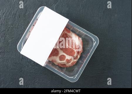 Rohes Schweinesteak in Vakuumverpackung, Logo-Mockup für Design. Stockfoto