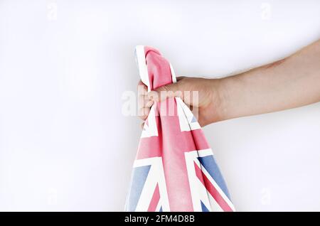 Leichte Nationalflagge Großbritanniens in der Hand vor weißem Hintergrund. Mann mit der Flagge des Vereinigten Königreichs von Großbritannien und Nord-Irel Stockfoto