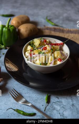 Indische Snacks Aloo jeera oder Kartoffelpüree mit Pfeffer und gehackten Zwiebeln gemischt. Nahaufnahme. Stockfoto