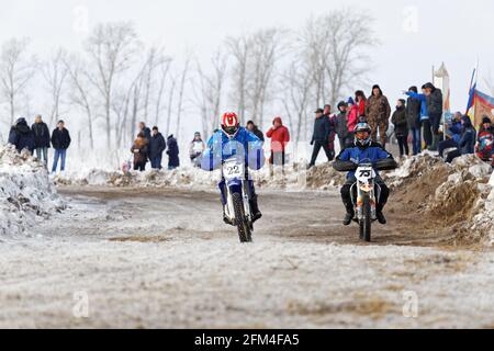 Uljanowsk, Russland - 06. Februar 2016. Winter-Motocross-Rennen 2016. Zwei Biker Rennen sich auf der Winterstrecke. Stockfoto