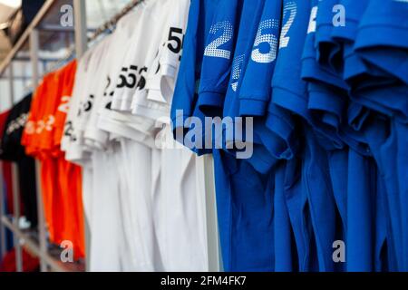 Ansicht von bunten T-Shirts auf Kleiderbügeln in einer Kleidung ausgesetzt Kaufen Stockfoto