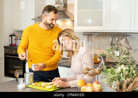 Glückliches Paar in der Küche. Romantisches junges Paar, das frisches Obst und Kaffee zubereitet. Gesundes Leben und Liebe. Lächelnde Menschen leben zusammen. Stockfoto