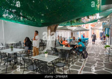 Paros, Griechenland - 28. September 2020: Griechisches Restaurant im Schatten der Bäume in der Stadt Parikia auf der Insel Paros. Stockfoto