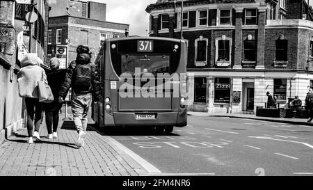 Kingston upon Thames London, 04 2021. Mai, Black and White Image Tree Anonymous Mädchen oder Frauen, die gemeinsam auf dem Bürgersteig einen Bus erreichen Stockfoto