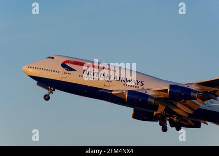 British Airways Boeing 747 Jumbo Jet-Linienflugzeug G-CIVD, das in der Dämmerung am Flughafen London Heathrow, Großbritannien, in hellblauem Himmel abfliegt. Schein des Sonnenuntergangs Stockfoto