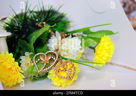 Zwei Halsketten aus goldenem Zubehör mit einem Schmetterling und einem Tänzer mit Rosen Stockfoto