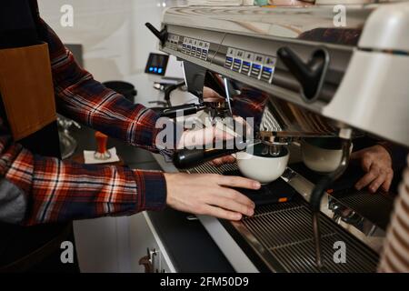 Barista, der Kaffee mit einer Kaffeemaschine zubereitet Stockfoto