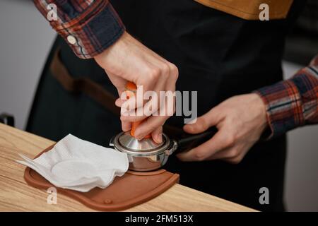 Der Barista mahlen frisch gerösteten Kaffee und bereitet eine Tasse Kaffee zu. Stockfoto