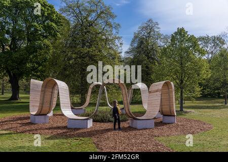 Kew Gardens, Richmond, Großbritannien. Mai 2021. Sommer bei Kew: Die geheime Welt der Pflanzen. Model genießt die immersive Skulptur 'Please be seated' von Paul Cocksedge. Das immersive Sommerfestival umfasst die wunderbare Welt der Pflanzenbiodiversität durch neu in Auftrag gegebene interaktive Kunstinstallationen mit Musik, Klang und Farbe. Im Zentrum des Festivals stehen sechs riesige ‘„Plantscapes“, die über die Kew Gardens verteilt sind und die britische Artenvielfalt feiern und vor ihrem Niedergang warnen. Amanda Rose/Alamy Live News Stockfoto