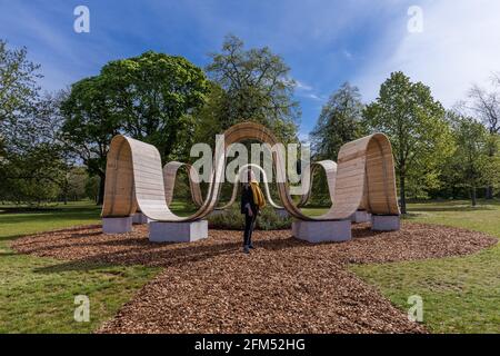 Kew Gardens, Richmond, Großbritannien. Mai 2021. Sommer bei Kew: Die geheime Welt der Pflanzen. Model genießt die immersive Skulptur 'Please be seated' von Paul Cocksedge. Das immersive Sommerfestival umfasst die wunderbare Welt der Pflanzenbiodiversität durch neu in Auftrag gegebene interaktive Kunstinstallationen mit Musik, Klang und Farbe. Im Zentrum des Festivals stehen sechs riesige ‘„Plantscapes“, die über die Kew Gardens verteilt sind und die britische Artenvielfalt feiern und vor ihrem Niedergang warnen. Amanda Rose/Alamy Live News Stockfoto
