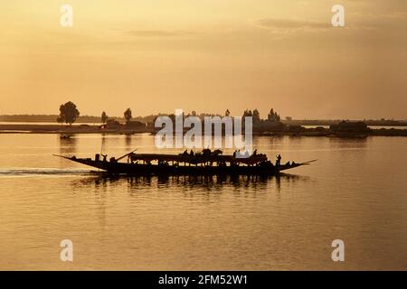 Im Abendlicht ist auf dem Niger ein Passagierpirogue unterwegs. 17.11.2003 - Christoph Keller Stockfoto